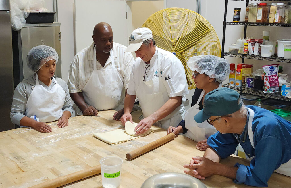 Chef from Bread Project teaching students how to fold puff pastry.